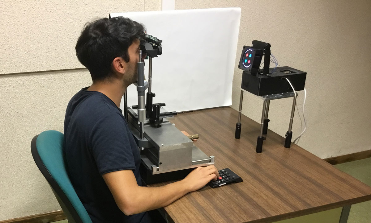subjectDSR-1200px Un hombre joven mira sentado a través de un aparato que le evalua la vista