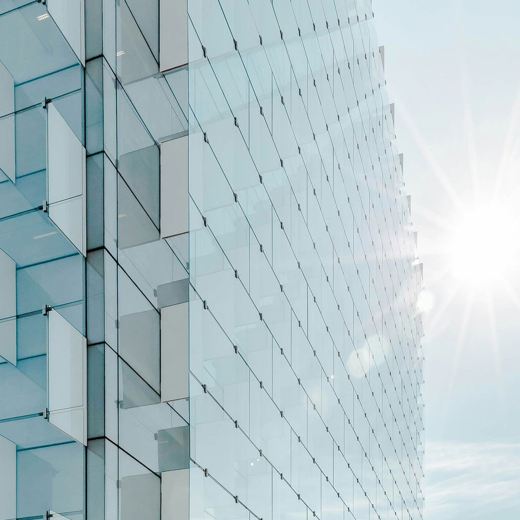 radiacción-solar-edificio-joel-filipe-aK0EmfPuktA-unsplash-cuad The sun on the right illuminating a glass facade of a modern building